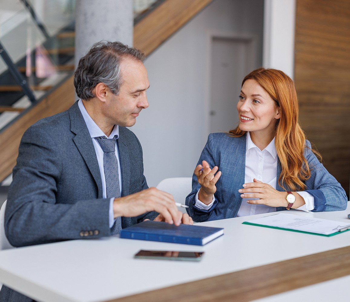 Real Estate Agent and customers discussing over blueprint